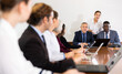 © JackF - Multiracial group of two mature male senior executives in formal suits holding business team meeting in conference hall