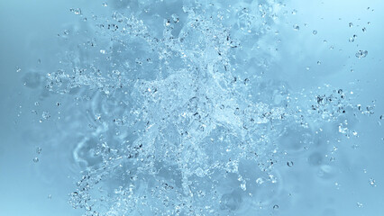 Poster - Water splash isolated on soft blue background.