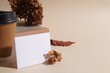 Dried hortensia flowers, sheet of paper and cardboard cup on beige table. Space for text