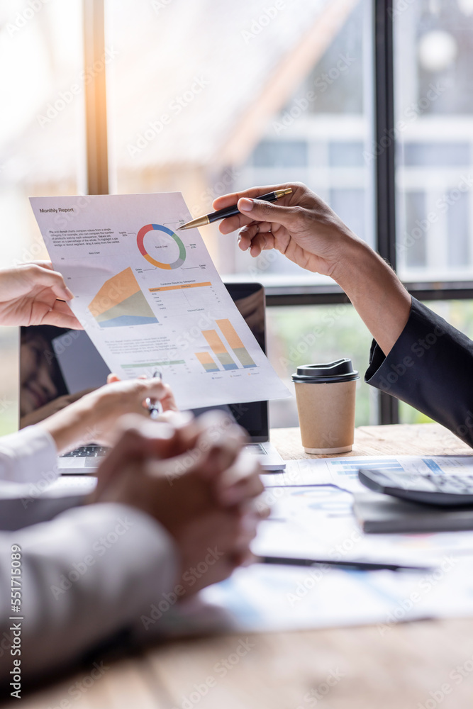 Group of confident business people point to graphs and charts to ...