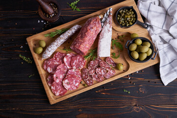 Wall Mural - Traditional Spanish fuet salami sausage on wooden cutting board at domestic kitchen