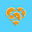 Juicy fresh orange slices forming heart shape on bright blue background. Minimal summer concept. Top view