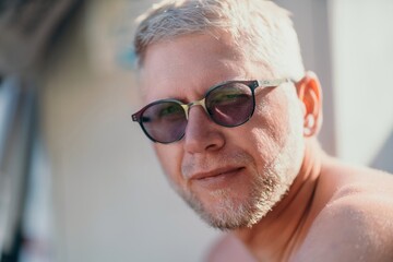 Outdoor portrait of mid aged happy caucasian man in sunglasses l