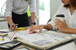 © Prathankarnpap - Architect team collaborating, planning development details and working with blueprints at office