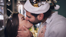 Party, Love And Couple Kiss At Christmas House Celebration For Bonding, Care And Appreciation. Marriage, Partner And Holiday Of Young People Kissing At Festive Event In Home Together.