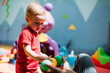 © dashamuller - Happy laughing boy 1-2 years old having fun in ball pit  in kids amusement park and indoor play center. Activity toys for little kid