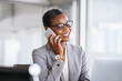 © Rido - Successful african business woman talking on phone in office