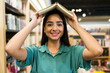 © AntonioDiaz - Portrait of a beautiful latin woman with a book on her head smiling