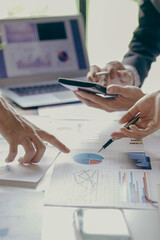 
Group of business people holding pen brainstorm financial analysis with financial graph document Calculator and computer to calculate budget and loan. Investment. Vertical image.