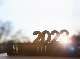 Wall Mural - 2023 new year bright sun rising, holy bible book and brilliant sunrise scenery
