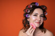 © Alexandr - portrait of a cute adult woman in curlers who washes her face with a sponge