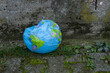 Erde in Not - Eingedrückter Beach Ball mit Globus-Design als Symbol für mangelnden Klima- und Umweltschutz.