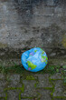 Erde in Not - Eingedrückter Beach Ball mit Globus-Design als Symbol für mangelnden Klima- und Umweltschutz.