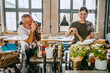 © Maskot - Happy female chef cooking food with male colleague photographing her in studio