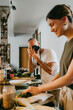 © Maskot - Colleague photographing female chef through camera while preparing food in studio