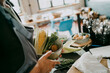 © Maskot - Midsection of female chef holding bowl of vegetables in studio kitchen