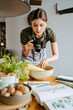 © Maskot - Food stylist photographing vegetable bowl using digital camera in studio