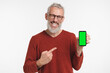 © InsideCreativeHouse - Positive caucasian mature middle-aged freelancer man pointing at mockup screen of cellphone smart phone, showing copy space place, mobile application online isolated in white background