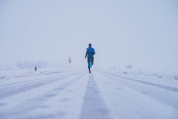 Wall Mural - man running in winter on the snow