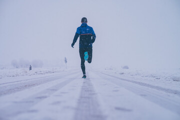 Wall Mural - man running in winter on the snow