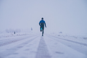 Wall Mural - man running in winter on the snow