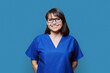 © Valerii Honcharuk - Smiling woman in blue scrubs uniform looking at camera on blue background