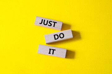 Wall Mural - Just do it symbol. Wooden blocks with words Just do it. Beautiful yellow background. Business and Just do it concept. Copy space.