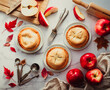 © Cavan Images - Top view of mini apple pies and apples on white marble counter.