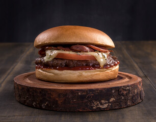 Wall Mural - delicious fast food cheeseburger on a rustic wooden table. cheese beef burger consists of bun bread, tomato, mozzarella, oregano, pepperoni slices and ketchup.