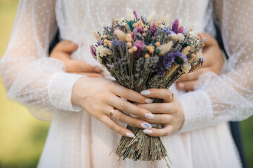 close-up of a bride with a bouquet of lavender and dry flowers