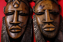 Vintage Wooden African Masks On Red Background, Top View