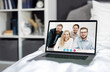 © MYDAYcontent - Laptop with corporate office team video call on screen standing on comfy bed with white linen