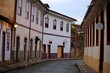 Street with old two-story houses in Portuguese colonial style, arched windows and doors, colored walls. City of Ouro Preto, Minas Gerais UNESCO cultural heritage