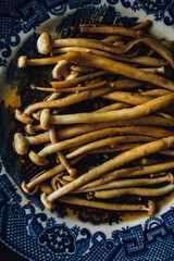 Sticker - Sautéed Enoki Mushrooms with garlic, sesame oil, soy sauce, East Asian cooking on blue and white Japanese plate