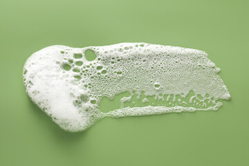 Sticker - Smudge of white washing foam on olive background, top view