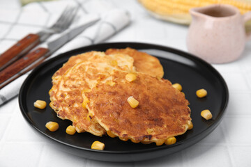 Tasty corn pancakes served on white table, closeup