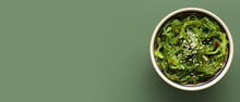 Bowl With Healthy Seaweed Salad On Green Background With Space For Text