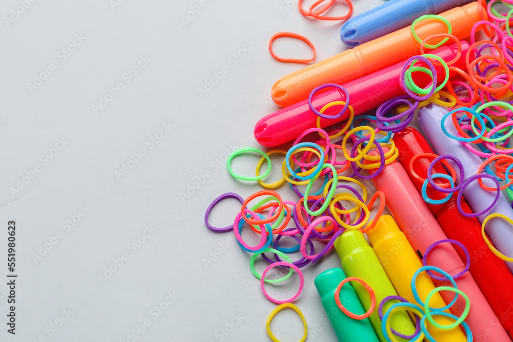 Colorful rubber bands and markers on white background