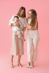 Poster - Happy lesbian couple with their little baby on pink background