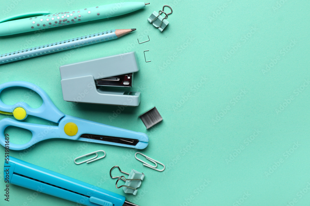 Set of stationery with stapler on color background