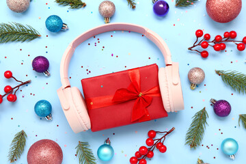 Headphones with gift and Christmas decor on blue background