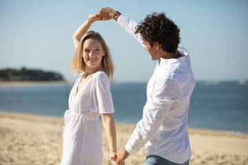 Wall Mural - young couple enjoying each other on a beach