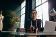 © Jacob Lund - Female designer sitting at her desk with coffee