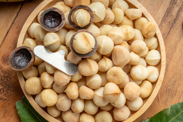 Wall Mural - Roasted Macadamia nut in wooden plate on wooden background, Macadamia nuts on wooden background.