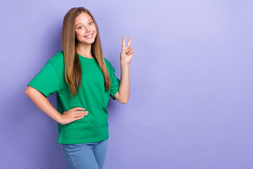 Poster - Photo of positive cheerful pretty lady dressed stylish clothes demonstrate v-sign stand empty space isolated on purple color background