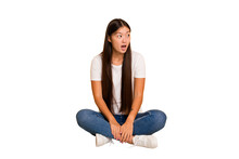 Young Asian Woman Sitting On The Floor Cutout Isolated Being Shocked Because Of Something She Has Seen.