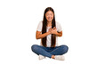 © Asier - Young asian woman sitting on the floor cutout isolated laughing keeping hands on heart, concept of happiness.