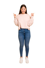 Wall Mural - Young asian woman standing, full body cutout isolated indicates with both fore fingers up showing a blank space.