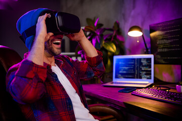 Photo of excited happy guy dressed glasses hat trying new video game modern device indoors workstation workshop home