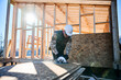 © anatoliy_gleb - Carpenter using circular saw for cutting wooden OSB board. Man worker building wooden frame house on pile foundation. Carpentry concept.